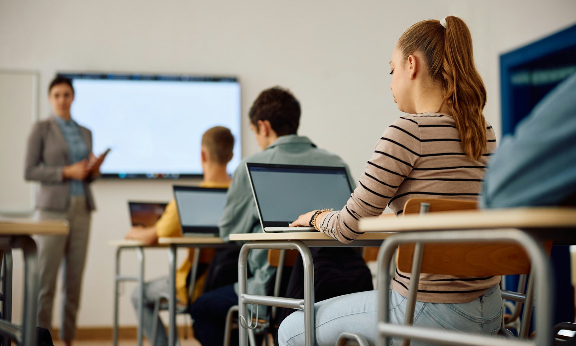 High school student and her classmates attending computer class in the classroom.